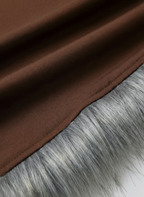 Close-up shot of a unique bralette top featuring fluffy grey faux fur cups and long, strappy brown wrap ties. Detail of exotic women's lingerie, festival wear bikini construction, and playful intimate apparel designs.