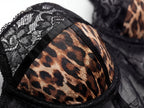 Close-up detail of a leopard print bra cup featuring intricate black floral lace trim and structured black satin piping. Detailed shot of sexy animal print women's lingerie, underwire construction, and romantic intimates.