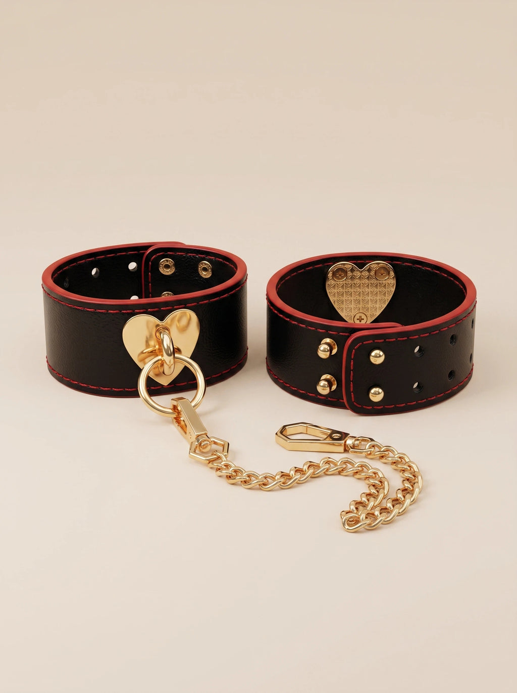 Full set of Velvet Fluxe VALENTINA luxury black leather and gold heart cuffs. Includes a detachable gold chain, adjustable studs, and crimson red accents. The ultimate high-end intimate accessory for romantic gifting and boudoir styling.