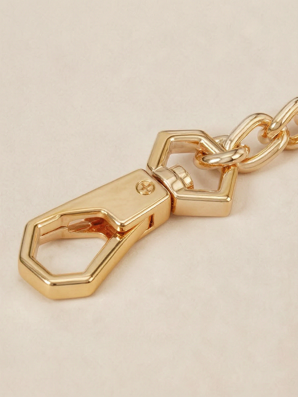 Close-up of the custom hexagonal gold snap-hook clasp on the Velvet Fluxe detachable chain. Showcasing the intricate hardware design of our luxury intimate restraint accessories.