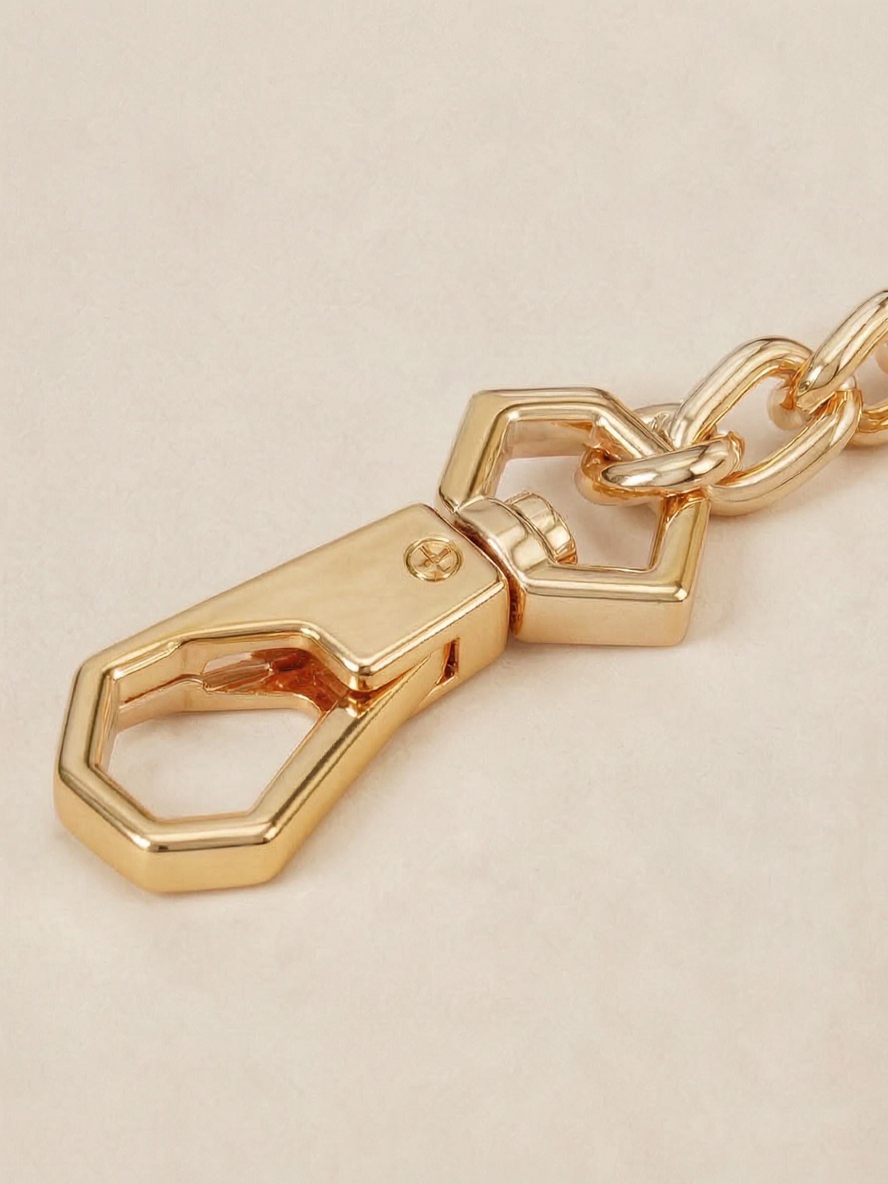 Close-up of the custom hexagonal gold snap-hook clasp on the Velvet Fluxe detachable chain. Showcasing the intricate hardware design of our luxury intimate restraint accessories.