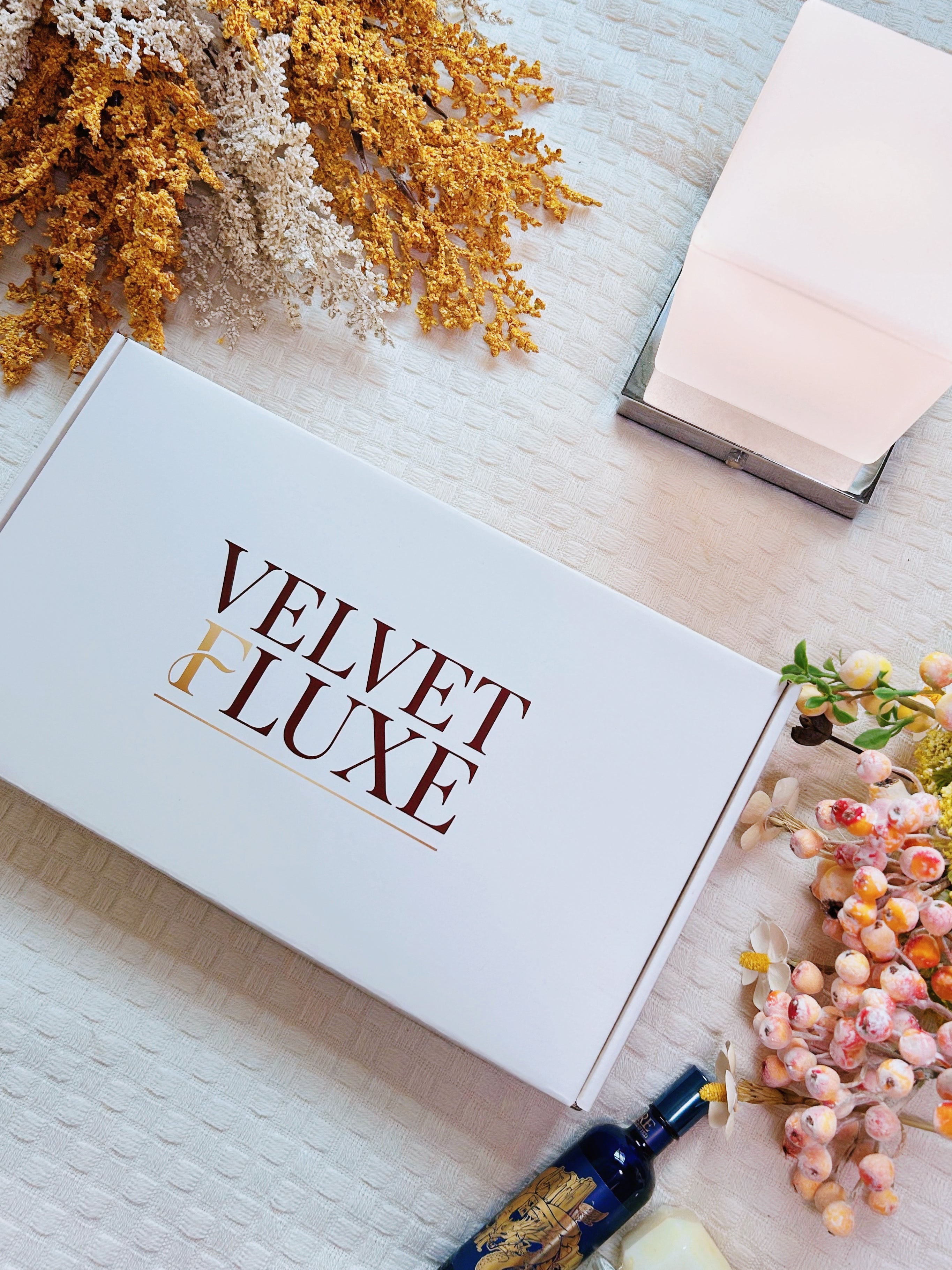 Velvet Fluxe deep burgundy luxury gift box opened revealing custom floral tissue paper, wine red suede cord, simulated wax seal sticker, and scented card poetry card, luxury lingerie unboxing ritual