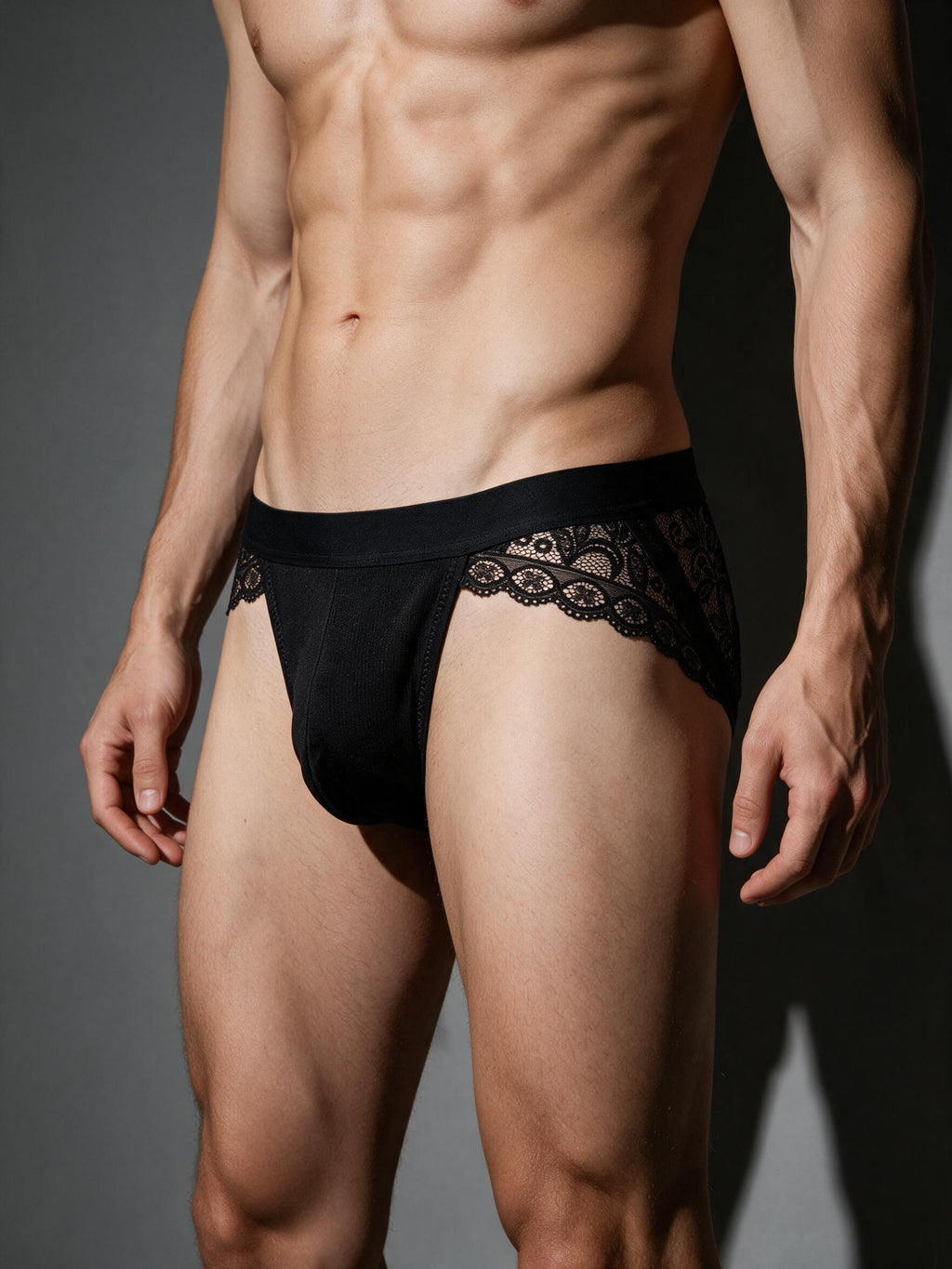 Side profile of a male model in the Velvet Fluxe HADEN low-rise jockstrap. Demonstrating the sculpting fit, breathable sheer lace side panels, and comfortable stretch.