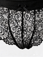 Close up of Velvet Fluxe NOCTURNE French men's sheer black lace boxer briefs. Product view showing the intricate floral lace pattern, solid black elastic waistband for support, and a subtle center bow detail.