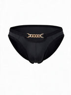 Flat lay product shot of AURELIUS black ice silk men's briefs, featuring a metallic gold chain waistband detail, front cutout, and premium nylon-spandex blend.