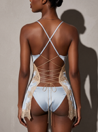 Model wearing the Velvet Fluxe Céleste ice blue satin slip dress from the back. Highlighting the dramatic open back, adjustable corset tie lacing, and lace-trimmed split skirt over a matching panty.