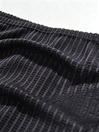 Macro fabric shot of Velvet Fluxe DOMEUP men's briefs in black, highlighting the intricate warp-and-weft weaving and heartbeat-inducing sheer texture.