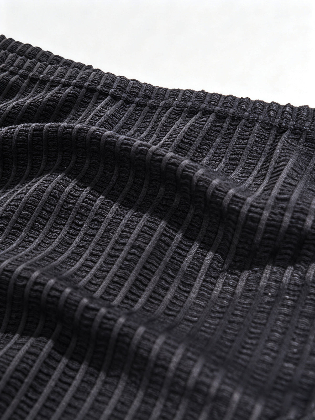 Macro fabric shot of Velvet Fluxe DOMEUP men's briefs in black, highlighting the intricate warp-and-weft weaving and heartbeat-inducing sheer texture.