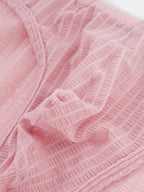 Close-up fabric detail of Velvet Fluxe DOMEUP men's briefs in pink, showing the reflective 3D ribbed texture woven from mercerized nylon and spandex.
