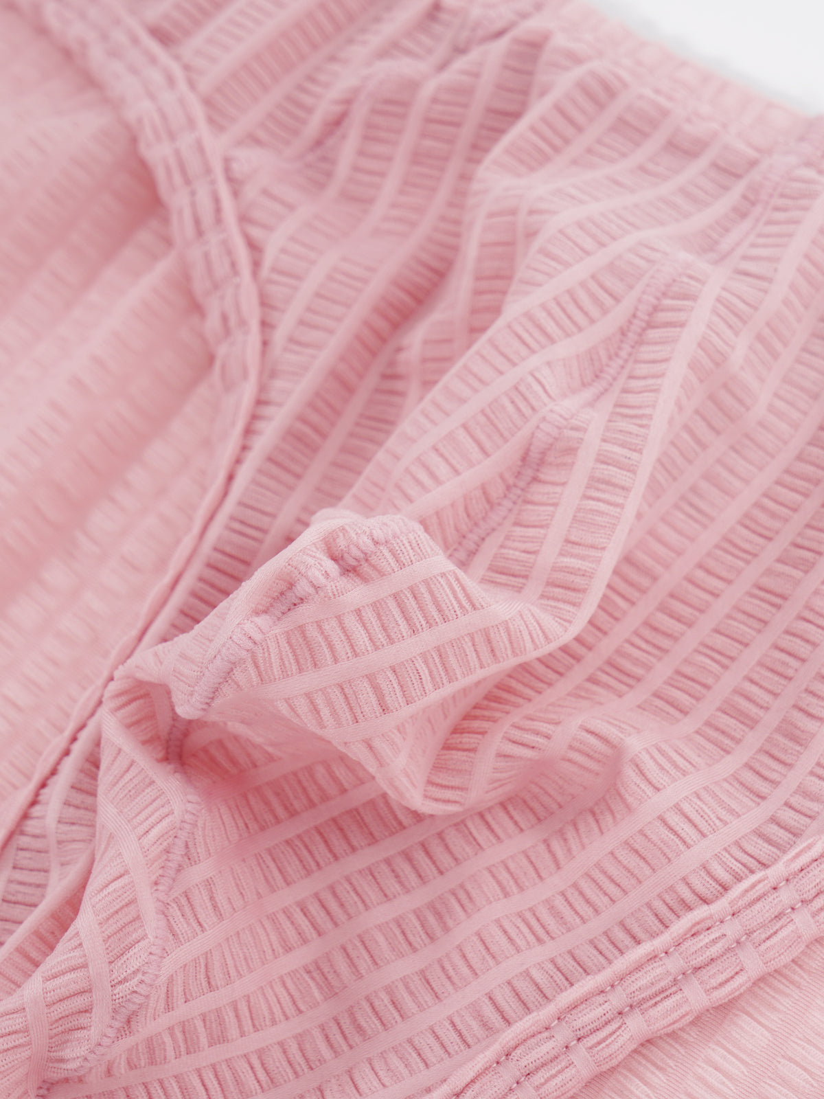 Close-up fabric detail of Velvet Fluxe DOMEUP men's briefs in pink, showing the reflective 3D ribbed texture woven from mercerized nylon and spandex.